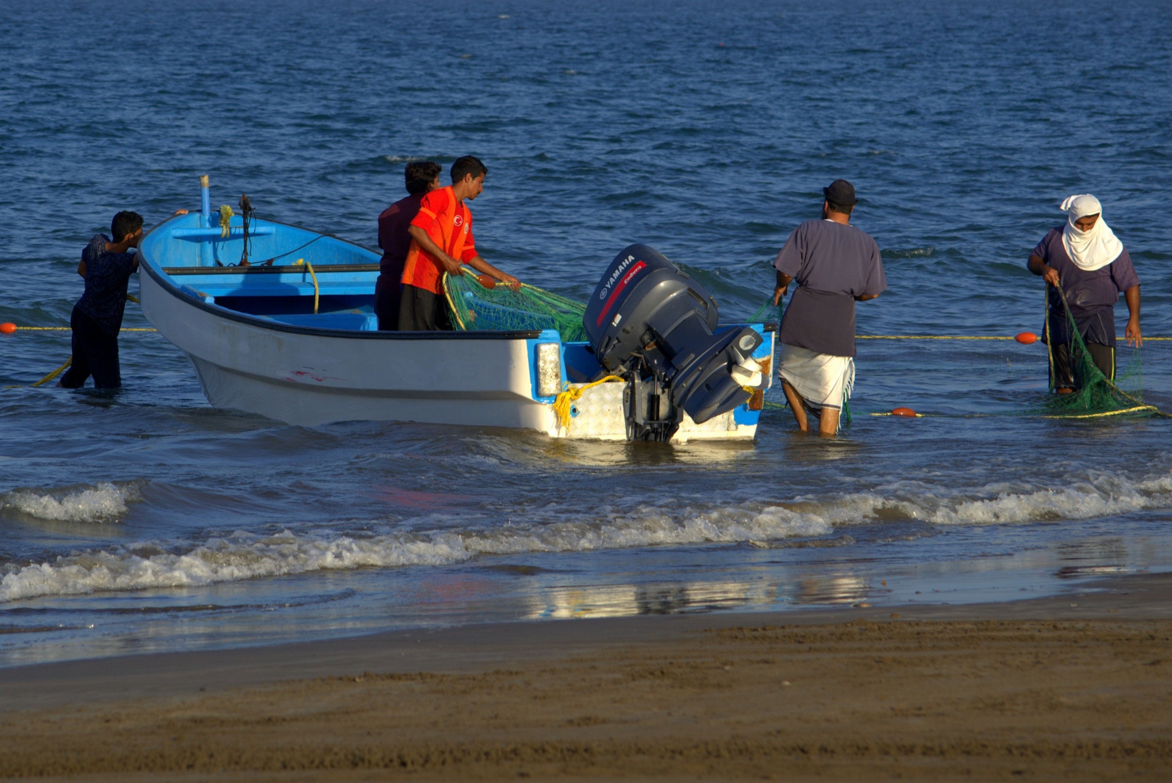 Fishermen preparing their boat and nets on the Omani coast